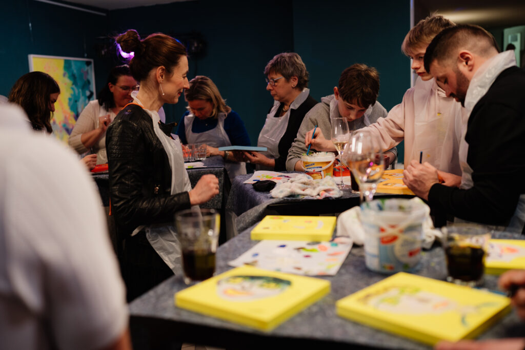 Menschen malen bei einem Blind Portrait Event gemeinsam den Star des Abends auf einer kreativen Feier.