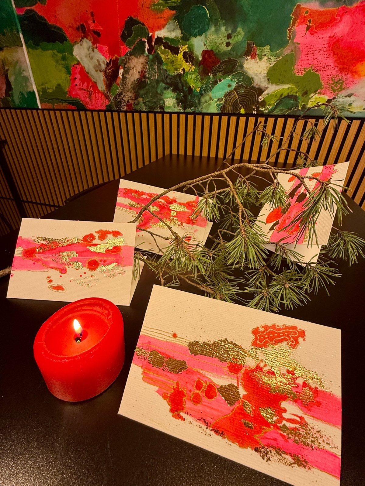 Fertige Karten mit Kerze vor einem Gemälde im Atelier